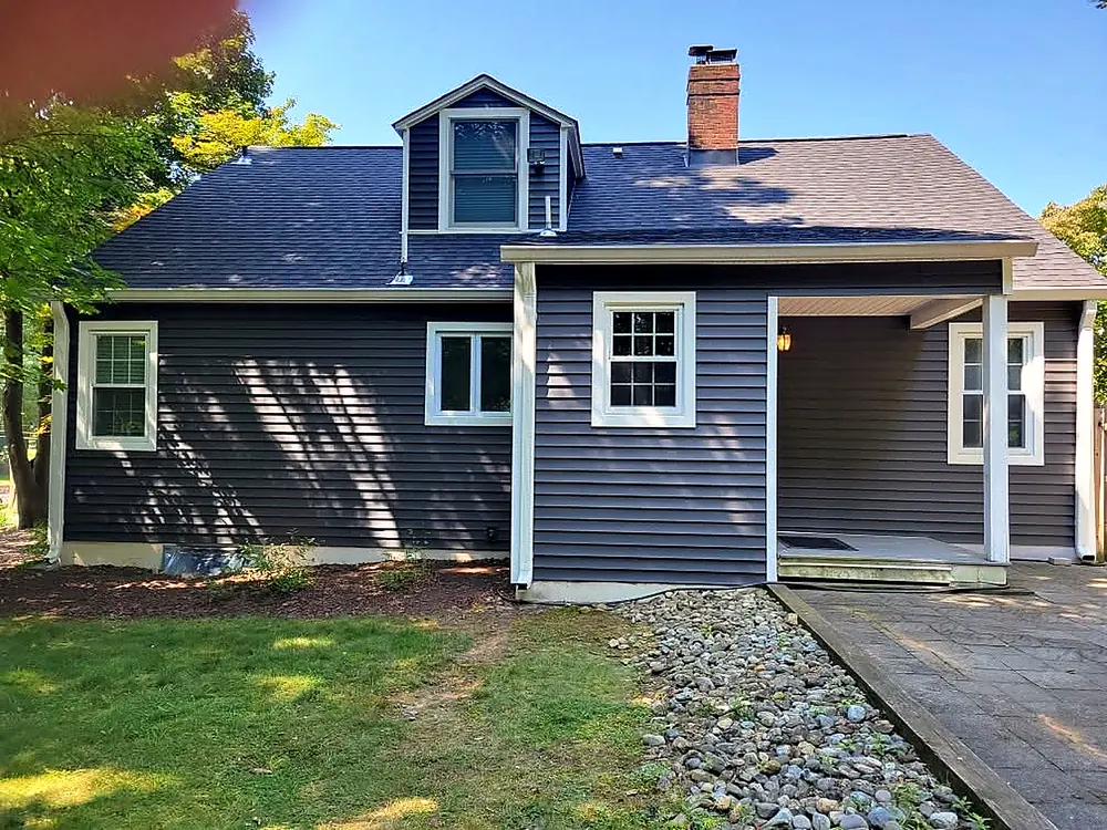 Rear of a navy-sided cape with new roof, gutters and trim