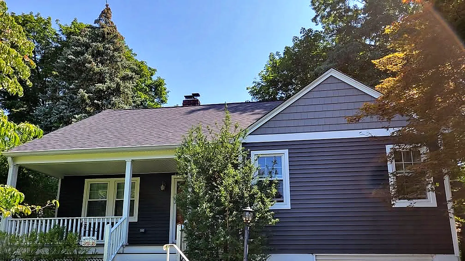 Cape Cod house with new navy siding, white trim and a new roof