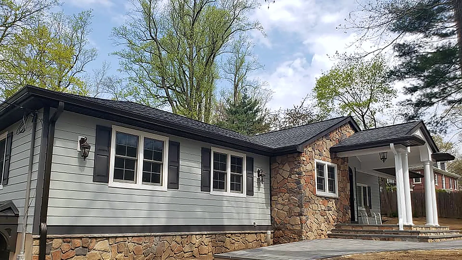Ranch with new gray lap siding, a stone-faced front, dark trim and a new dark shingle roof