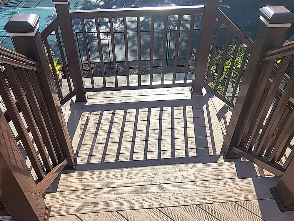 Composite deck boards and dark brown composite railings with post caps